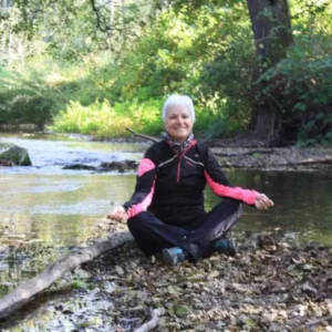 Photo de Simone GRUNFELDER, Accompagnatrice Holistique à Pfastatt, en position de méditation près de l'eau. Illustre la connexion corps-esprit pour la gestion du stress et du poids.